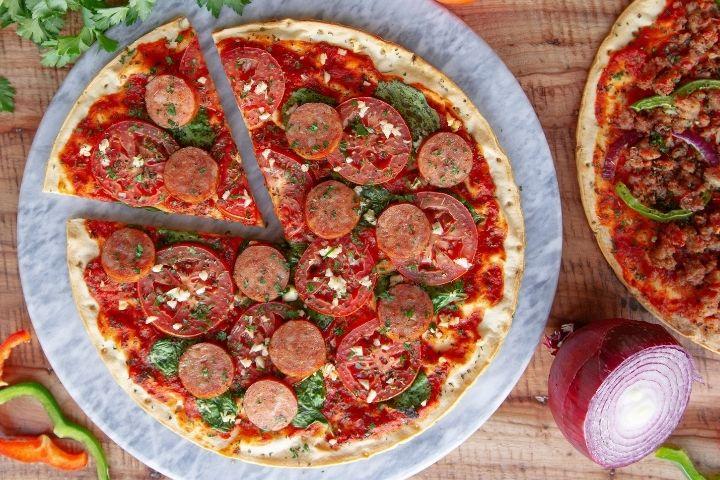 Overhead shot of a pizza topped with Pederson's Farms sliced Kielbasa.