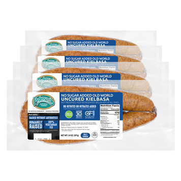 Four packages of Pederson's No Sugar Added Old World Uncured Kielbasa sausages arranged in a cascade with transparant background.